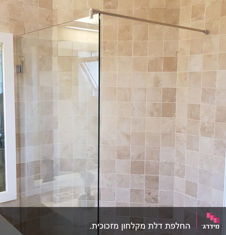 מקלחת עם קירות אריחים ודלת זכוכית